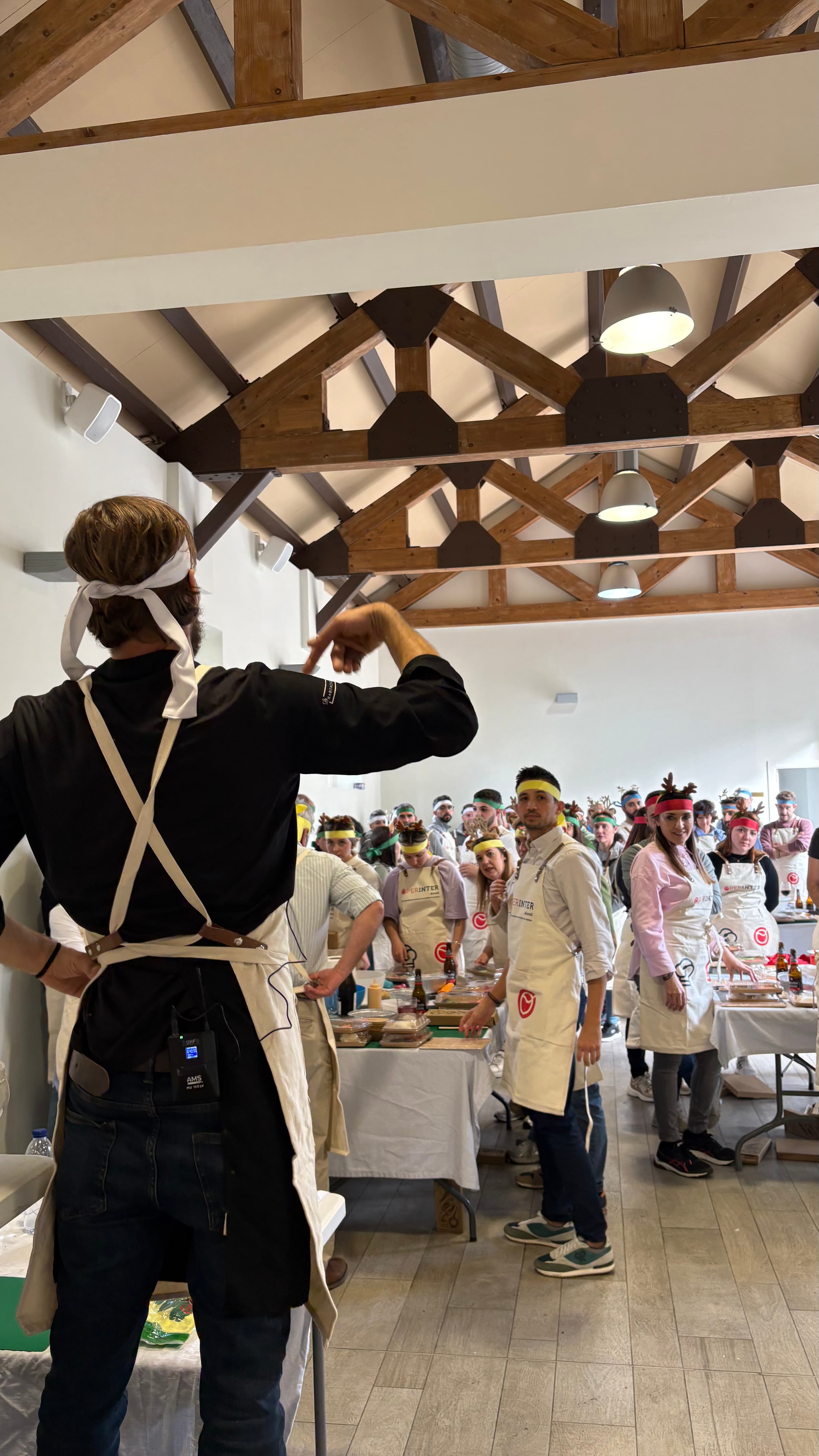 Grupo grande en un evento de team building de cocina con delantales y diademas