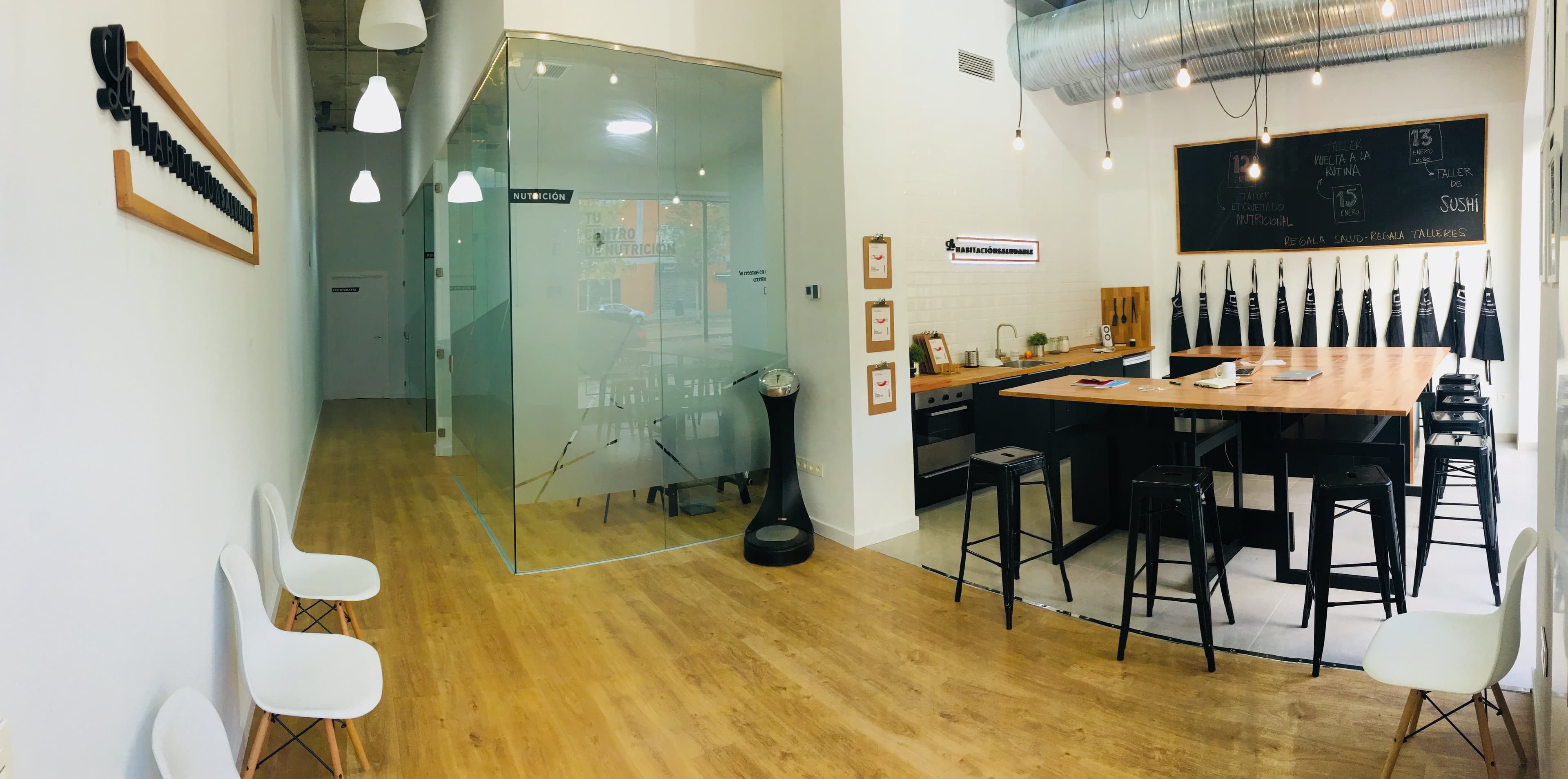 Interior de una sede de La Habitación Saludable: sala de espera, consulta de nutrición acristalada y zona de talleres de cocina